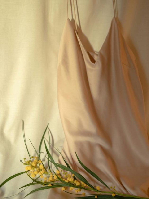 High quality slow fashion garment hanging next to a flower