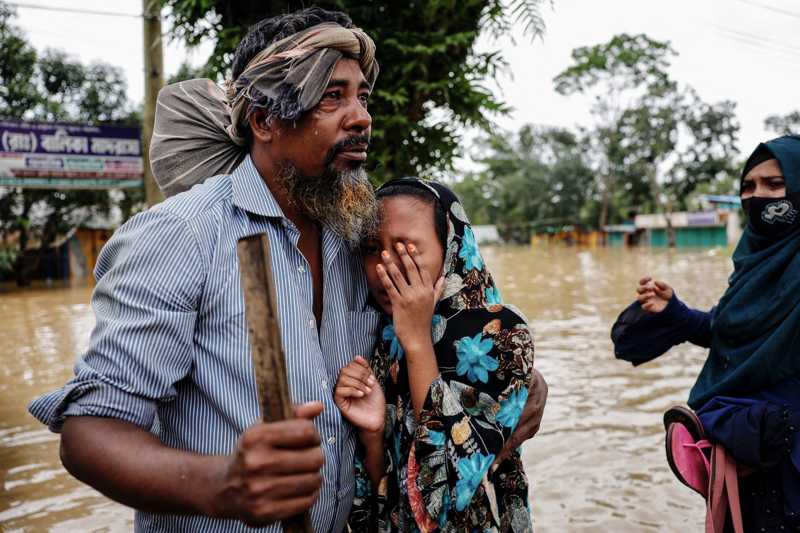 Saiful Islam cries after meeting his daughter Sadia Akter after four days as a severe flood hits the Lalpol area in Feni, Bangladesh, August 25, 2024. UK aid budget cuts threaten climate finance pledges