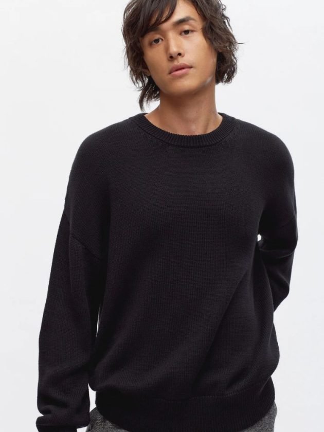 Model wearing black sweater from slow fashion brand Kotn
