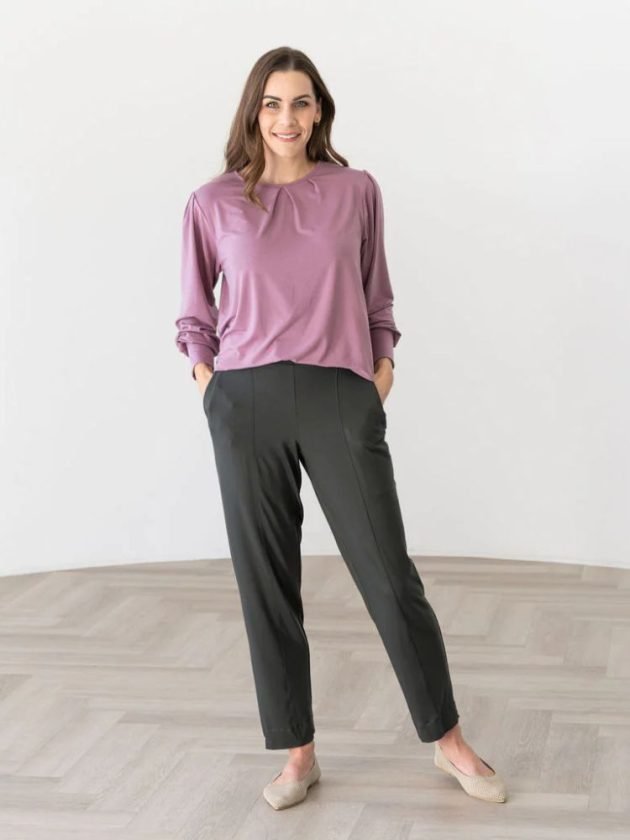 woman wearing pink blouse and gray pants from slow fashion brand
