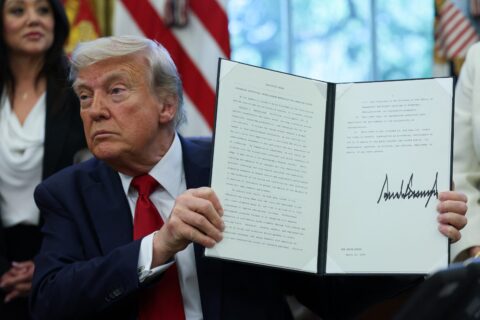 President Donald Trump holds a signed executive order in the Oval Office at the White House in Washington, D.C., U.S., April 23, 2025. REUTERS/Leah Millis. Trump's first 100 days: US walks away from global climate action