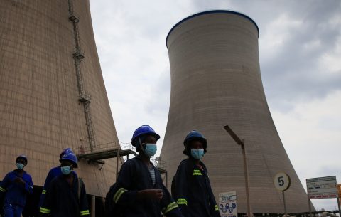 Workers walk beneath cooling towers at Hwange Power station's Phase 8, currently under construction, in Hwange, Zimbabwe, October 19, 2021