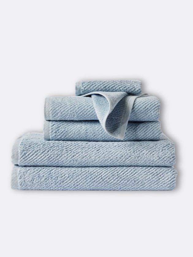 Stack of light blue organic cotton towels in varying sizes by COYUCHI