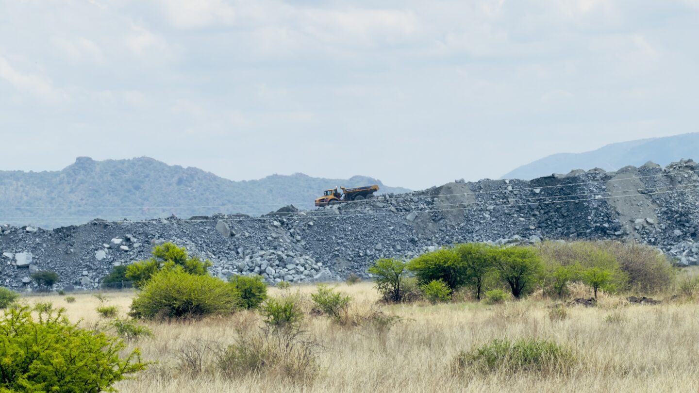 A lorry drives on a huge pile of grey rocks in South Africa