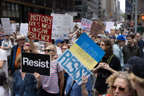 March in New York City shows people holding banners calling to protect the climate and resist