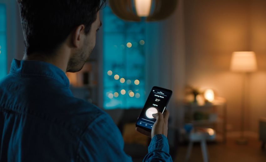 Man operates smart plug with his smartphone