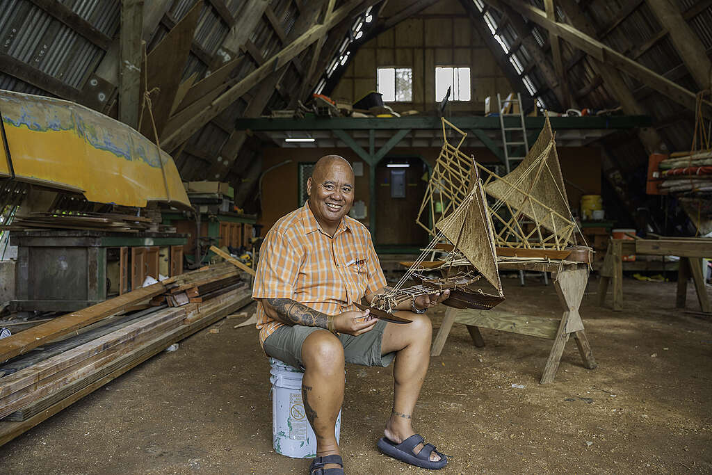 Expert navigator, Alson Kelen, holds a model of a traditional Marshallese caanoe.
