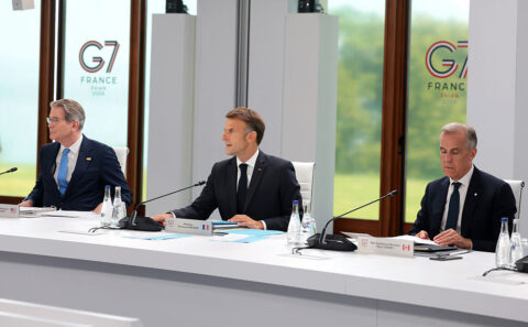 US Secretary of the Treasury Scott Bessent (L) sits in a chair reserved for US President Donald Trump as President of France Emmanuel Macron (C) and Prime Minister of Canada Mark Carney look on ahead of a working session on promoting economic growth with G7 leaders and partners, during the G7 Summit on June 17, 2026 in Evian-les-Bains, France