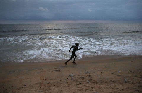 A child runs on the beach at the seaside favella of West Point on August 15, 2014 in Monrovia, Liberia.