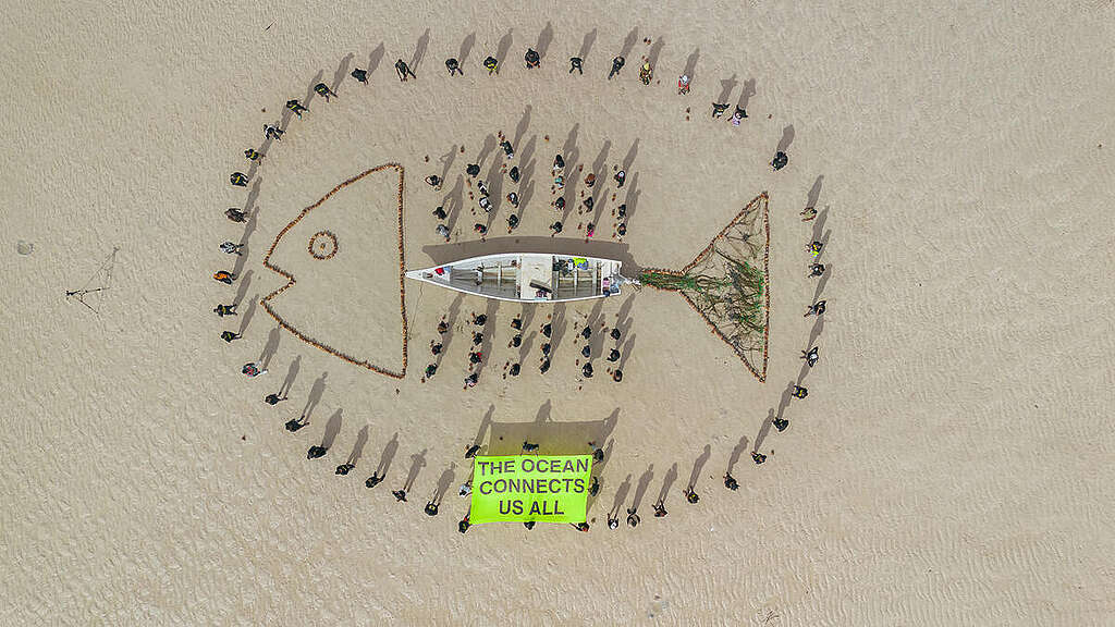 A sand installation created by volunteers and community members in Kenya, carrying the message "The Ocean Connects Us All" to highlight the interconnected challenges facing coastal communities across Africa and the need for ocean protection.
