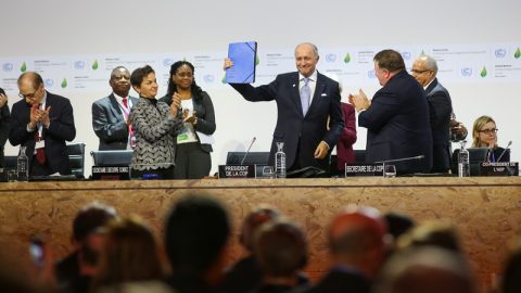COP21 president Laurent Fabius holds up the text of the Paris Agreement.
