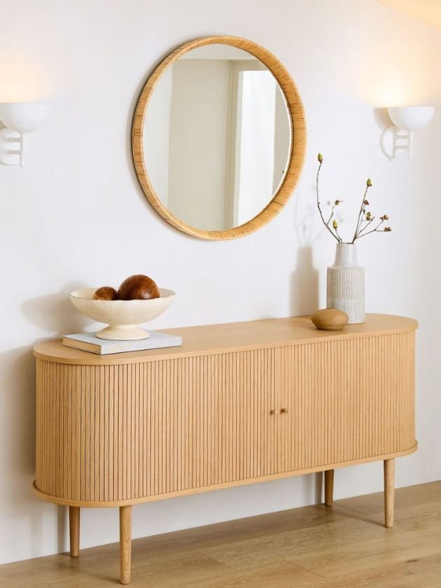 Rattan circle mirror hanging above sideboard