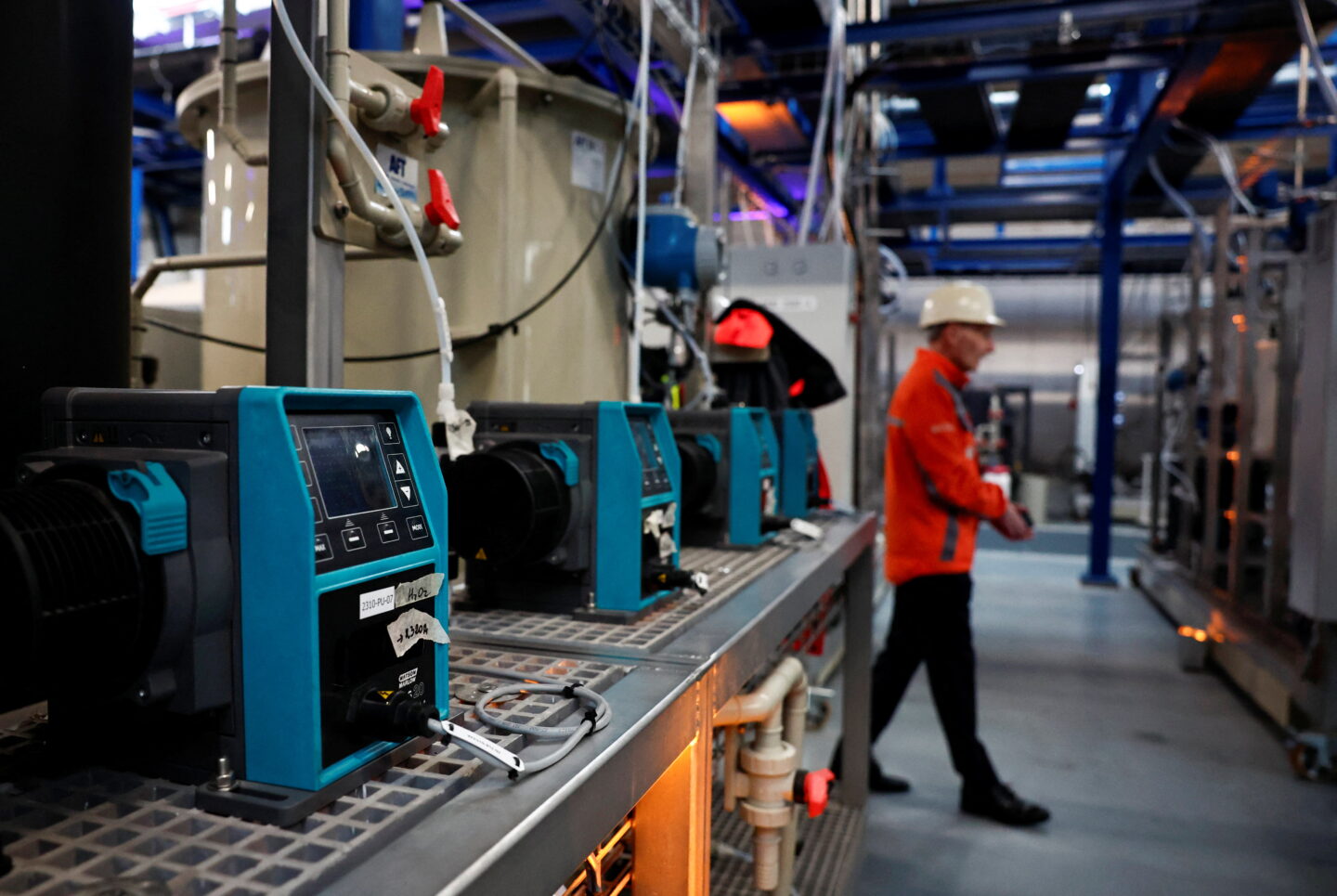 An engineer walks past a pump at the battery recycling pilot plant installed in the Eramet Research & Innovation center in Trappes, near Paris, France