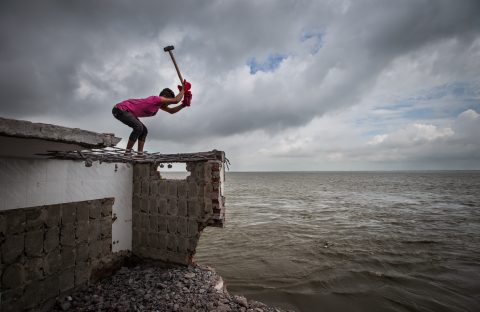 Billal Hossain breaks his house in Shariatpur, Bangladesh, and collects the last brick to shift to another place to settle. (Photo: Moniruzzaman Sazal / Climate Visuals Countdown)